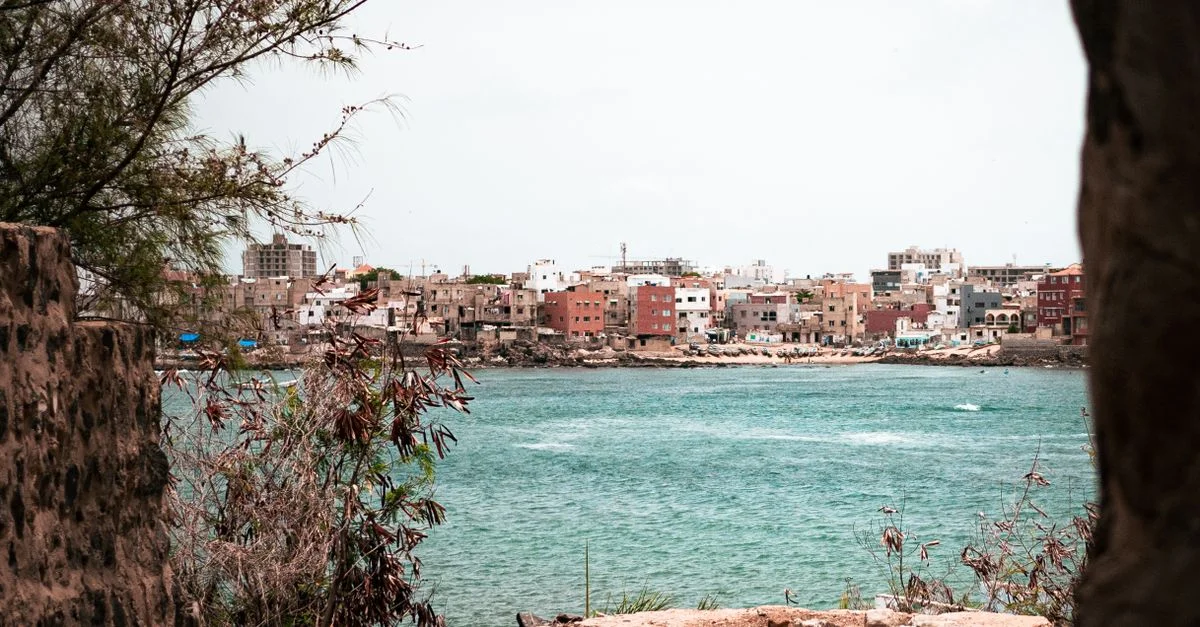 Découvrez les couleurs vibrantes et l'architecture unique d'une ville côtière au Sénégal à travers cette vue pittoresque.