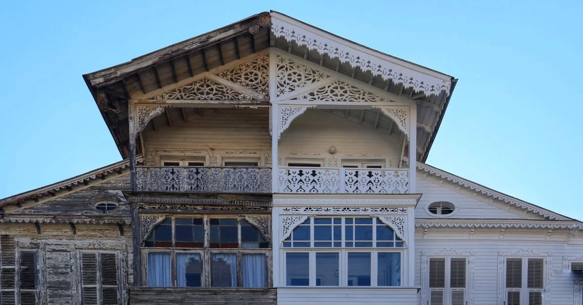 Une vue détaillée de la façade d'une maison en bois à moitié rénovée, montrant l'ancien contre le nouveau.